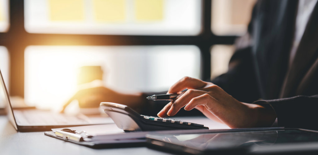 Frau am Schreibtisch mit Taschenrechner